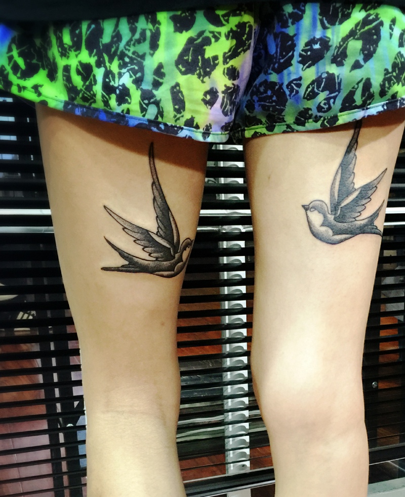 点击大图看下一张：双腿部互相凝望的小燕子纹身图片