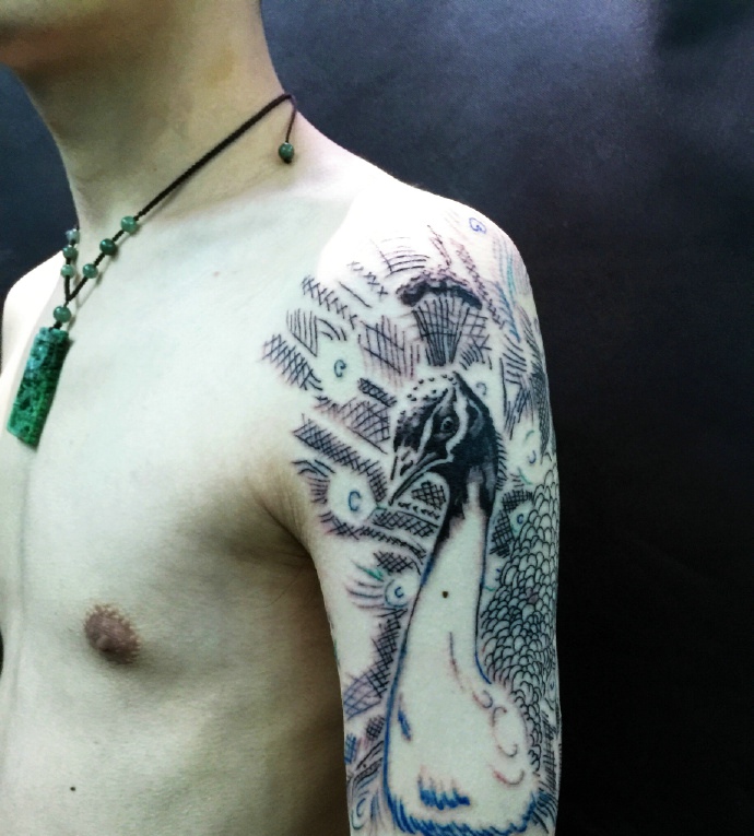 点击大图看下一张：天生爱漂亮的花臂孔雀纹身刺青
