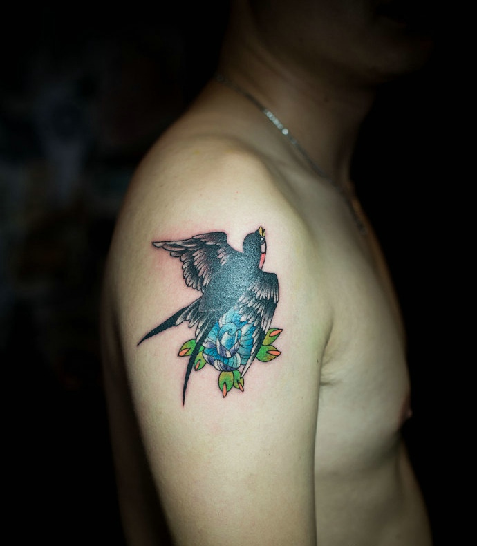 点击大图看下一张：大臂一只小燕子采花的个性纹身图片