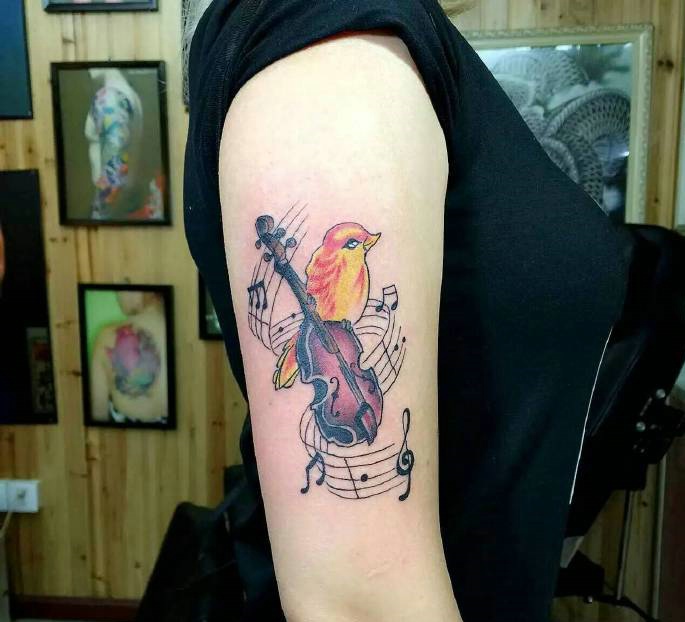 点击大图看下一张：一只爱音乐的小鸟手臂纹身刺青