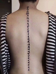 个性男士脊椎部的梵文纹身刺青