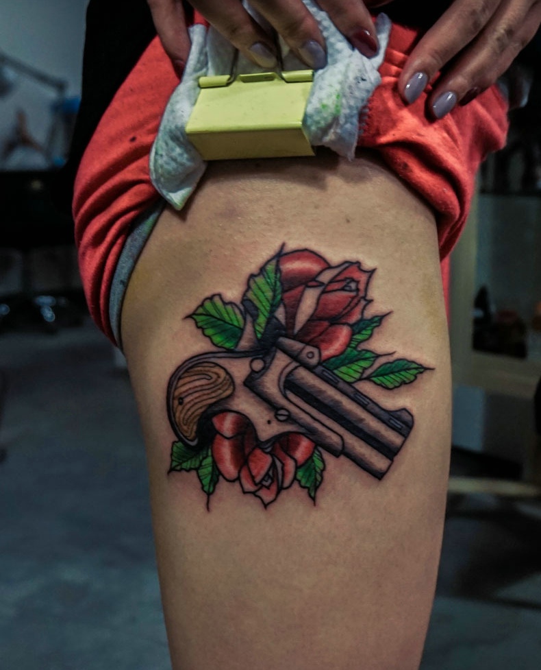 点击大图看下一张：红玫瑰与水枪结合的腿部纹身图案