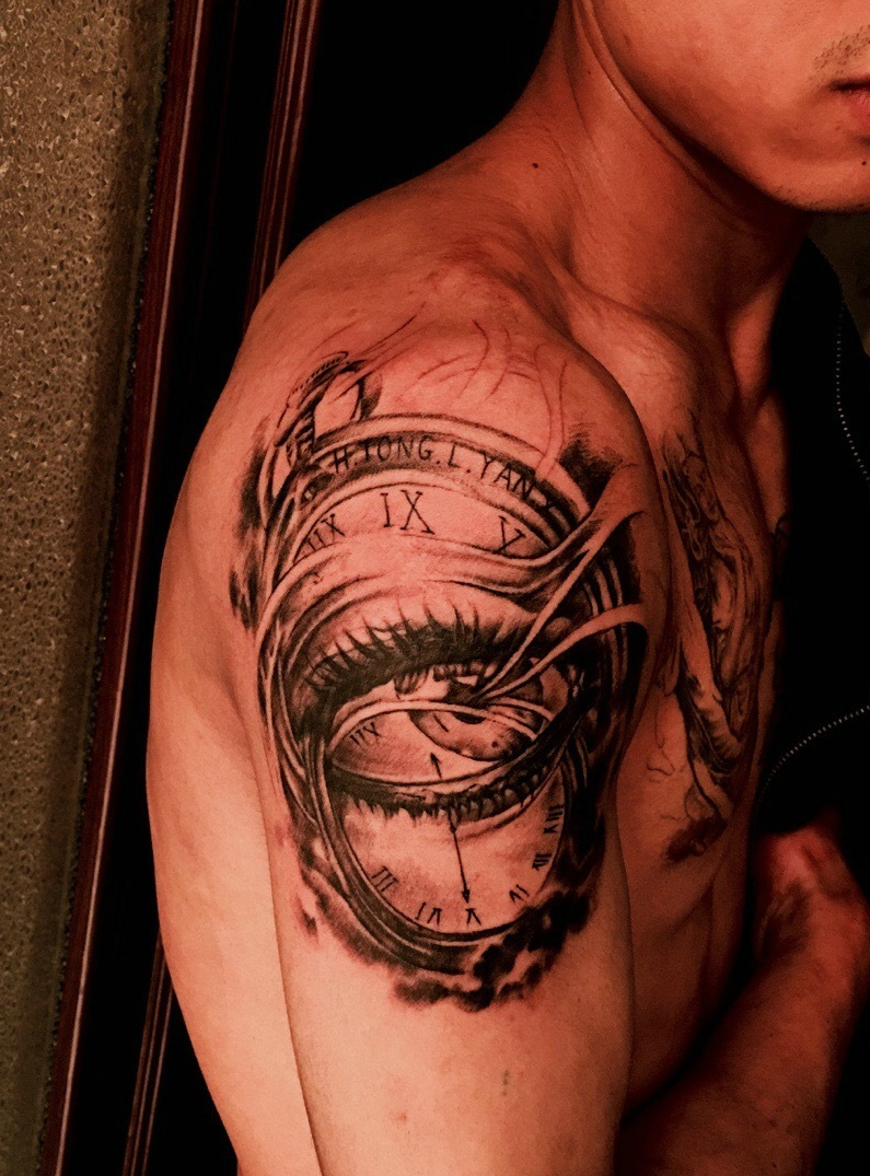 点击大图看下一张：钟表与眼球一起的大臂纹身刺青