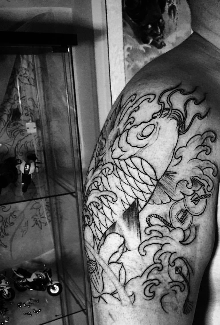 点击大图看下一张：大臂简陋低调的线条鲤鱼纹身刺青