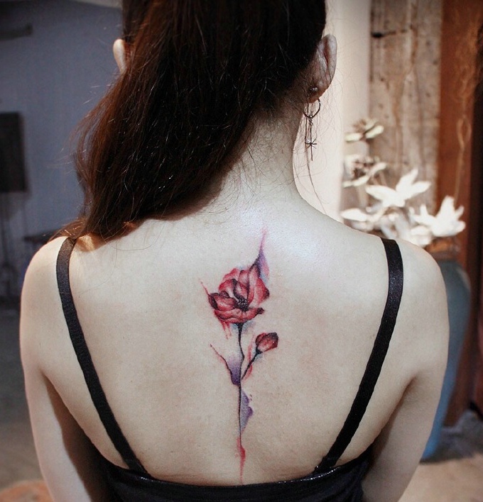 点击大图看下一张：脊椎部一只花朵纹身刺青美丽动人
