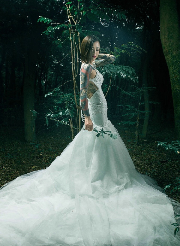 点击大图看下一张：森林里的花臂纹身新娘笑容满面