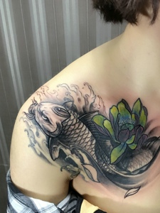 女生胸口抢眼的鲤鱼与莲花纹身图案