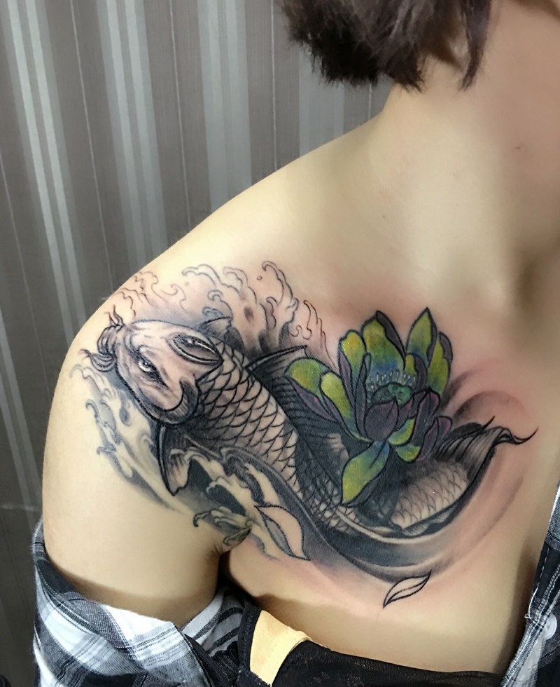 点击大图看下一张：女生胸口抢眼的鲤鱼与莲花纹身图案