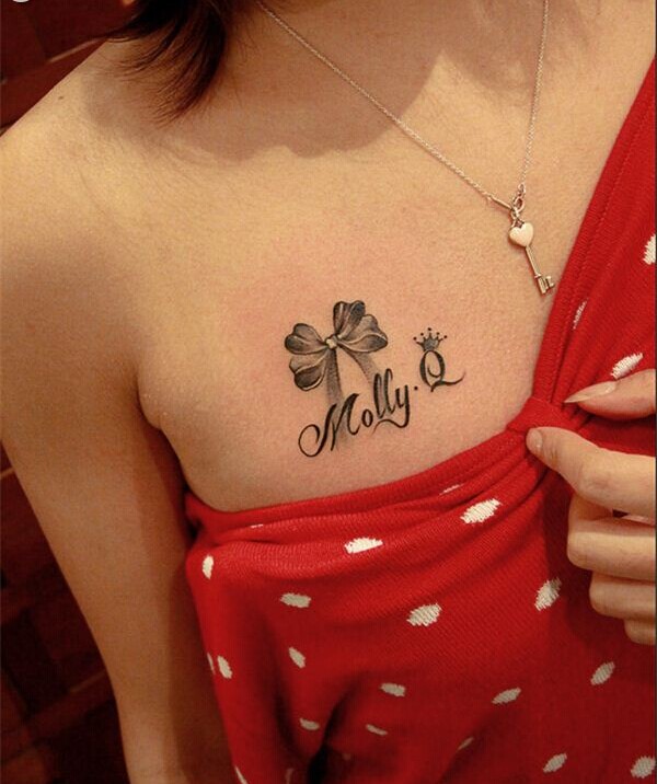 点击大图看下一张：女性胸前蝴蝶结字母纹身