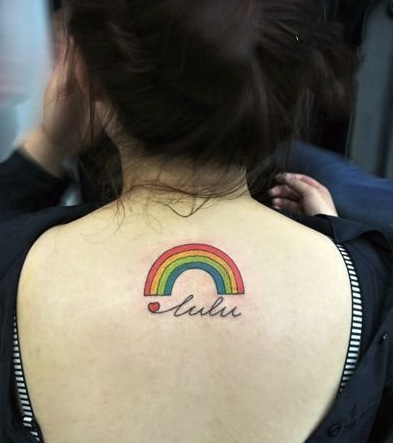 点击大图看下一张：女生背后简洁大方的小彩虹纹身
