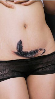 个性女性腹部羽毛纹身盖疤痕