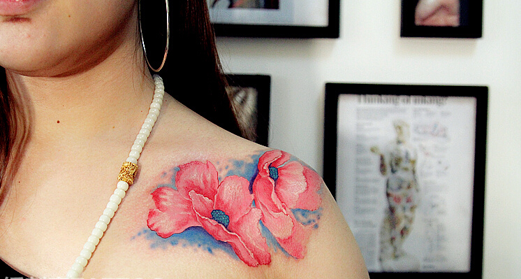 点击大图看下一张：女性胸前的粉红色花朵纹身