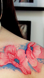 女性胸前的粉红色花朵纹身