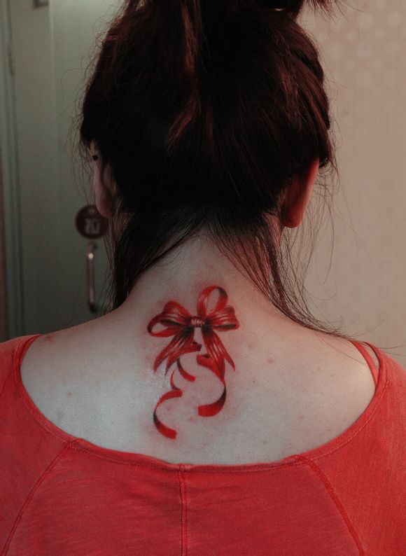 点击大图看下一张：女性背部漂亮的蝴蝶结纹身