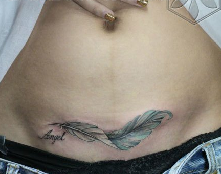 点击大图看下一张：女人腹部经典潮流的羽毛纹身图案