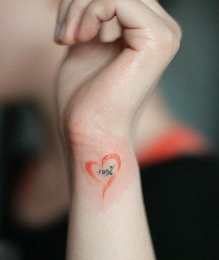 点击大图看下一张：女生手腕处彩色小爱心刺青图案