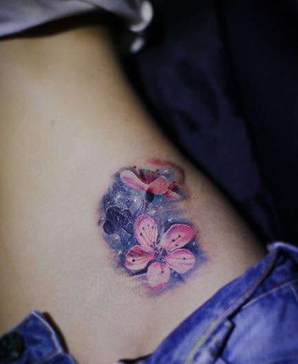 点击大图看下一张：美女腹部漂亮标致的花卉与星空纹身图案
