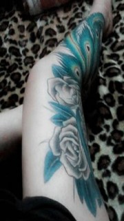 腿上大面积不同色彩的花卉纹身图案