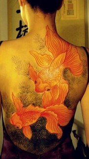 女生后背彩色的金鱼纹身图案