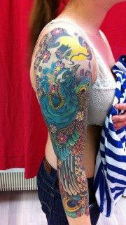 女性漂亮的花臂孔雀纹身