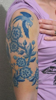 女性大臂上青花色纹身