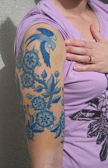 点击大图看下一张：女性大臂上青花色纹身