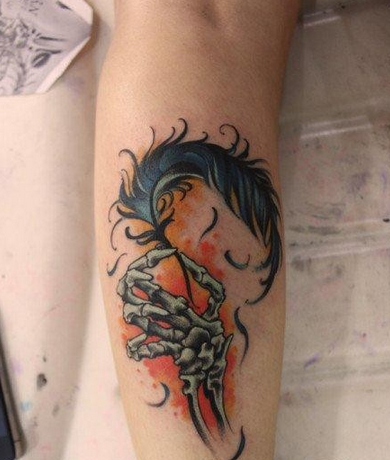 点击大图看下一张：女人腿部唯美的骷髅手与羽毛纹身图片