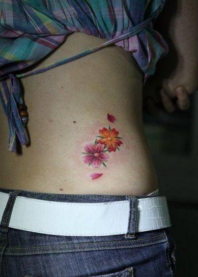 点击大图看下一张：美女腰部精美小巧的樱花纹身图片