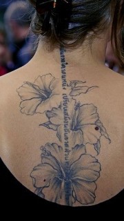 女性背部淡墨色花朵英文纹身