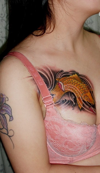 点击大图看下一张：女性胸部上的鱼刺青纹身图案