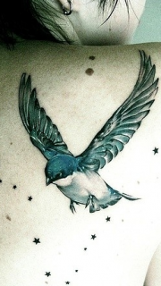 女性背部飞翔的小鸟纹身