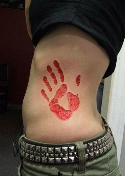 点击大图看下一张：女生腰部割肉掌印纹身