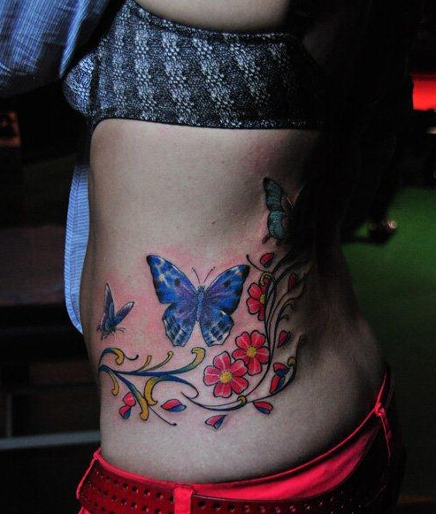 点击大图看下一张：女人腰部漂亮的彩色蝴蝶花卉藤蔓刺青图片