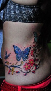 女人腰部漂亮的彩色蝴蝶花卉藤蔓刺青图片