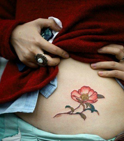 点击大图看下一张：女人腹部精美的花卉纹身图案大全