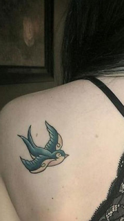 女孩背部绿色燕子纹身