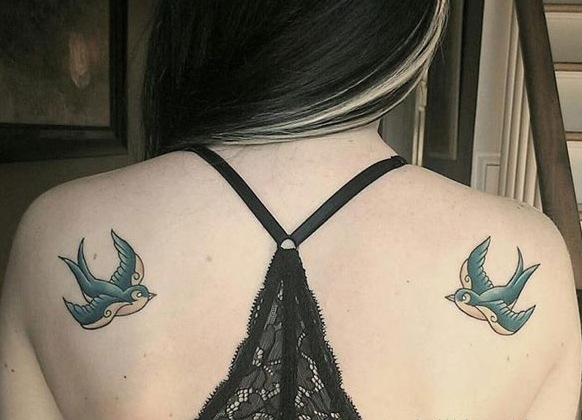 点击大图看下一张：女孩背部绿色燕子纹身
