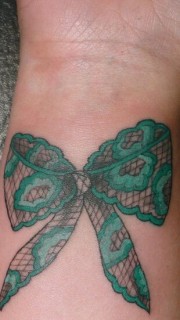 手腕上的绿色蝴蝶结纹身图案