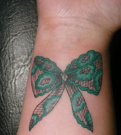 点击大图看下一张：手腕上的绿色蝴蝶结纹身图案
