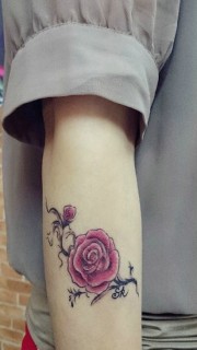手臂玫红色花朵纹身