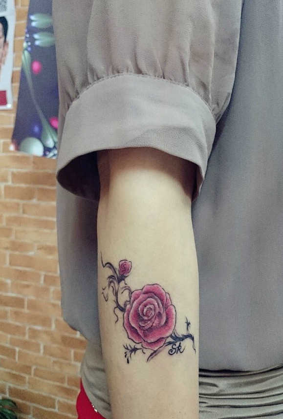 点击大图看下一张：手臂玫红色花朵纹身