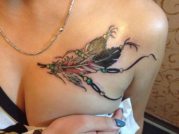 点击大图看下一张：女生胸部漂亮的彩绘羽毛纹身图案