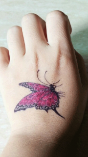 女性手背玫瑰色蝴蝶纹身图案