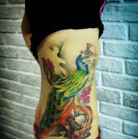 点击大图看下一张：女生腰部漂亮的孔雀纹身图案