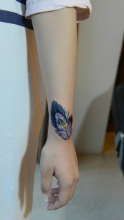 女生手臂上个性十足的彩色羽毛纹身