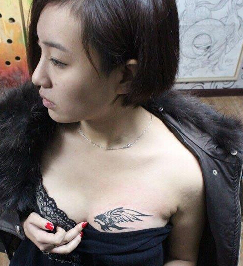 点击大图看下一张：美女胸部典型的图腾燕子纹身图案