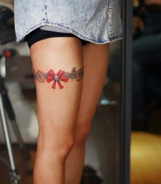 点击大图看下一张：腿部大红色水彩蝴蝶结纹身图案