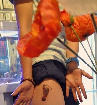 点击大图看下一张：个性美女腿上可爱脚印纹身图案