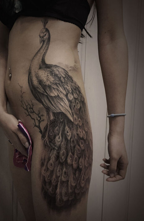 点击大图看下一张：美女腰臀上个性的黑灰孔雀纹身