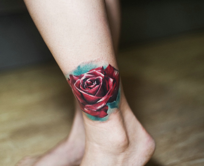 点击大图看下一张：落在腿部的一朵红玫瑰纹身图片